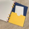 Bolsillo amarillo sobre fondo azul marino con notas guardadas en la agenda de discos 2026-27, diseño Plumas